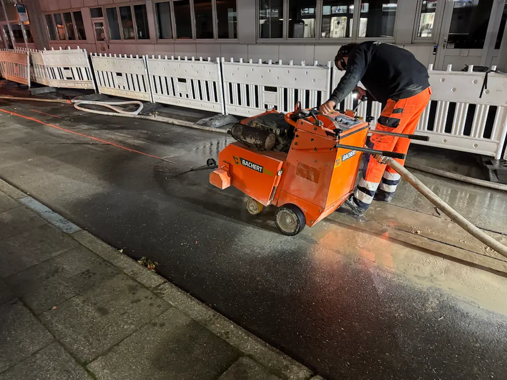 Zertifizierter Tiefbaubetrieb führt präzise Asphaltschnitte für die Grundstücksentwässerung in Hamburg durch.